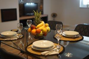 波热加Apartman Sveti Rok的餐桌,配有一碗水果和酒杯