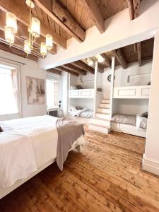 NeuvilleLa Demeure du Capitaine的一间卧室设有一张大床,铺有木地板。