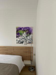茨雷斯Apartments Kremenic的卧室配有一张床,墙上挂有绘画作品