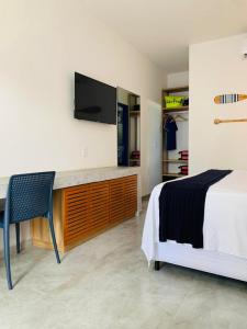 卡莫辛Meditarranee Residence的一间卧室配有一张床和一张书桌及电视