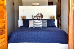 伊卡普伊Casa Mandakarú的一间卧室配有一张蓝色的床和白色床头板