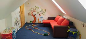 哈拉霍夫哈拉霍夫斯卡旅馆的一间儿童间,配有沙发和树壁画