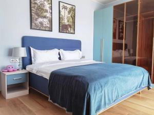 布拉格yipin villa的一间卧室配有蓝色的床和蓝色的毯子