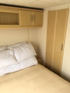 斯凯格内斯Sea Breeze at Winthorpe Skegness的小房间配有一张带白色枕头的床