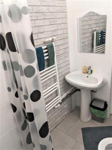 皮特什蒂Casa Agape的白色的浴室设有水槽和镜子