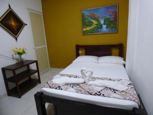 米卡Hostal Alto de la Montaña的一间卧室配有带毛巾的床