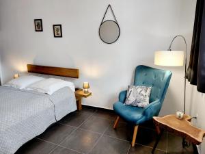 皮特尔角城Charmant pied-à-terre coeur de ville的一间卧室配有一张床和一张蓝色椅子