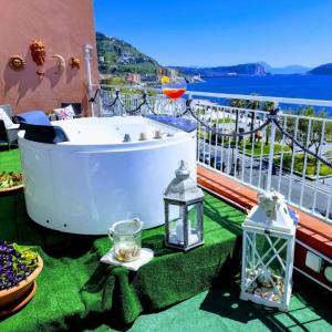 波佐利Terrazza Miracapri的阳台上设有浴缸,享有水景
