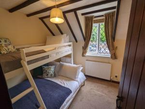 艾恩布里奇Butchers Cottage的一间卧室配有双层床和沙发