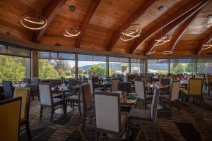 蒂阿瑙卓越酒店的用餐室设有桌椅和窗户。