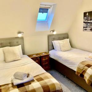 波特里Skye View Cottage的带窗户的客房内设有两张单人床。