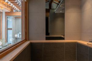 首尔Luxury hanok with private bathtub - SW10的一间带大镜子和窗户的浴室