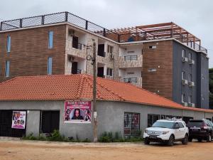 罗安达28A, Lumir Apartamento #8, Luanda的前面有停车位的建筑