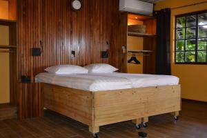 威利布罗德岩科克小屋酒店的一间卧室配有一张带白色床单的木床