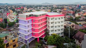马尼拉MySpace Hotel @BGC的一座城市的粉红色和紫色建筑