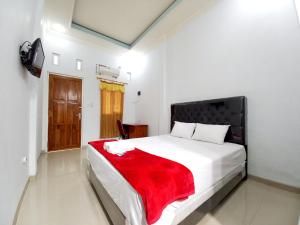PatiHarmony House Syariah near Alun Alun Pati Mitra RedDoorz的一间卧室配有一张床铺,床上铺有红色毯子