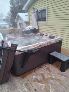 兰辛Outdoor Hot Tub and Cozy King Bed的热水浴池位于房子外