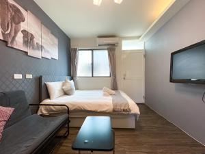 台中市逢甲想居的小房间设有一张床和一台平面电视