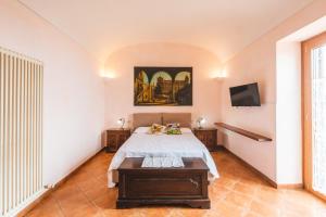 索伦托Casale Ianus - Country house with Panoramic View的卧室配有一张床,墙上配有电视。