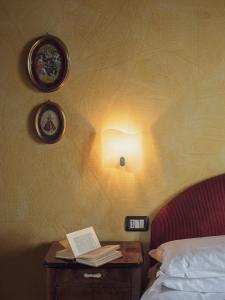 萨索马可尼Fattorie di Montechiaro的一间卧室配有一张床和一张桌子及一本书