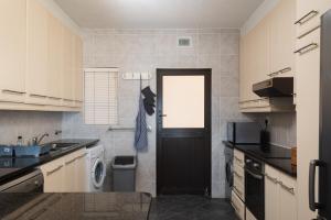 巴利托The Bay 2的厨房设有黑色的门和一台洗衣机