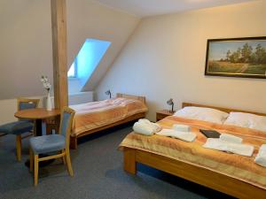 新赫拉迪Wellness hotel Rezidence的一间设有两张床、一张桌子和一把椅子的房间
