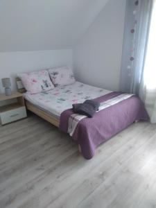 波拉齐克Noclegi U Janusza 536-310-384的一间卧室配有一张带紫色毯子的床