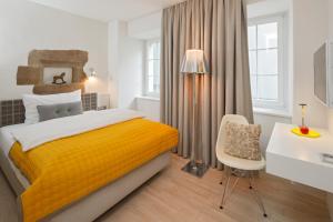 苏黎世索思丽酒店的一间卧室配有黄色的床和一张书桌