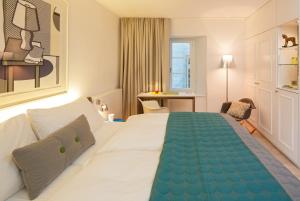 苏黎世索思丽酒店的酒店客房设有一张大床和一张书桌。