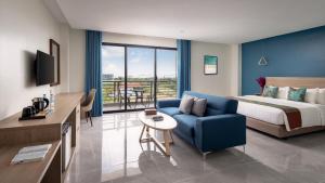 白马市Vakara Hotel Kep的酒店客房,配有床和蓝色的沙发