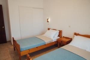阿里拉斯Pagonia Apartments的带2张桌子的客房内的2张单人床