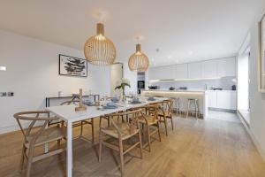 伦敦Stayo Apartments Southbank的厨房以及带长桌和椅子的用餐室