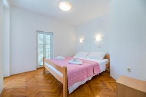巴斯卡Apartments Melania & Antonia的白色卧室配有一张带粉色毯子的床