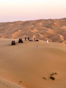 里瓦Liwa Nights ليالي ليوا的一群站在沙漠沙子里的人