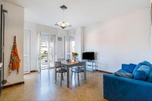 安杰拉Iris Apartment Lago Maggiore的客厅配有桌子和蓝色沙发