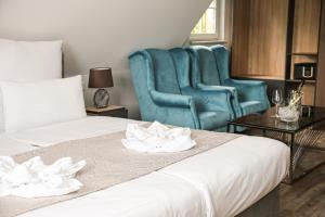 库罗阿尔滕堡Hotel Waldeslust的酒店客房,设有两张床和一张蓝色椅子