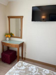 伊斯坦布尔亚福兹酒店的一间设有桌子、镜子和凳子的房间