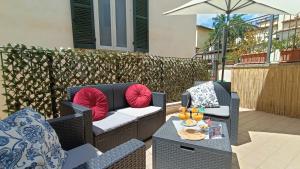 拉奎拉Cozy House con Corte Privata in Centro Storico AQ的庭院设有2把藤椅和遮阳伞