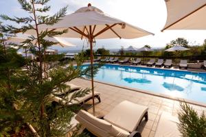 马林斯卡蓝波度假酒店的酒店游泳池设有椅子和遮阳伞