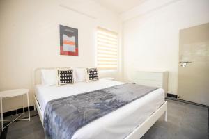 海得拉巴Neemtree Apartments的卧室配有一张带两个枕头的大白色床