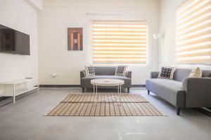 海得拉巴Neemtree Apartments - Somajiguda的客厅配有两张沙发和一张桌子