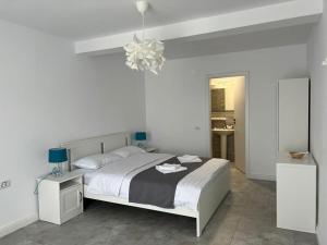 旧瓦马VAMA BLUE的白色卧室配有一张床和一个吊灯