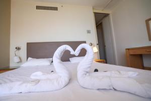 内坦亚Park hotel的两条毛巾,形状像天鹅,坐在床上
