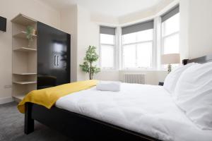 爱丁堡ALTIDO Haymarket的一间卧室配有一张大床,床上有黄色的毯子