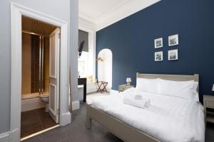 爱丁堡ALTIDO Haymarket的一间拥有蓝色墙壁和一张白色大床的卧室
