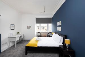 爱丁堡ALTIDO Haymarket的蓝色卧室配有一张床和一张书桌