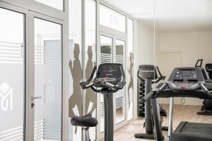 克里斯托港Aparthotel Marina Drach的健身房设有两个跑步机和两个椭圆机