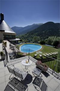维耶拉维耶拉旅馆的一个带桌椅的阳台和一个游泳池