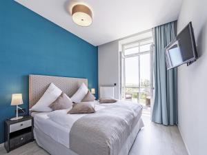 欧巴德伍斯图Sonnenblume in der Seefahrtschule的一间卧室配有一张蓝色墙壁的床和电视