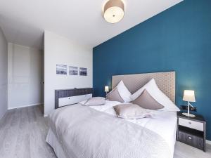 欧巴德伍斯图Sonnenblume in der Seefahrtschule的一间卧室设有一张蓝色墙壁的大床